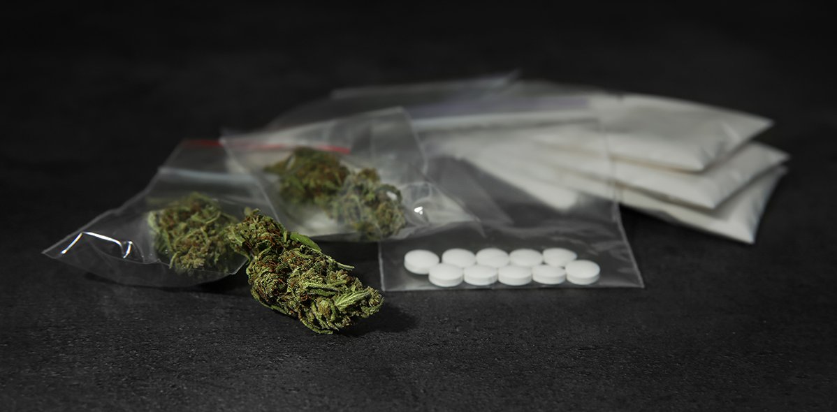 Unterschiedliche illegale Drogen auf einem grauen Tisch